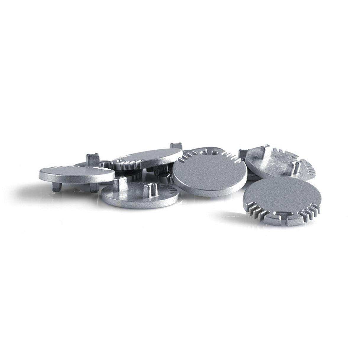 Seven silver End caps for Alu Round LED profile, each round and flat with raised tabs, notched edges, and a cable hole, are scattered on a white surface.