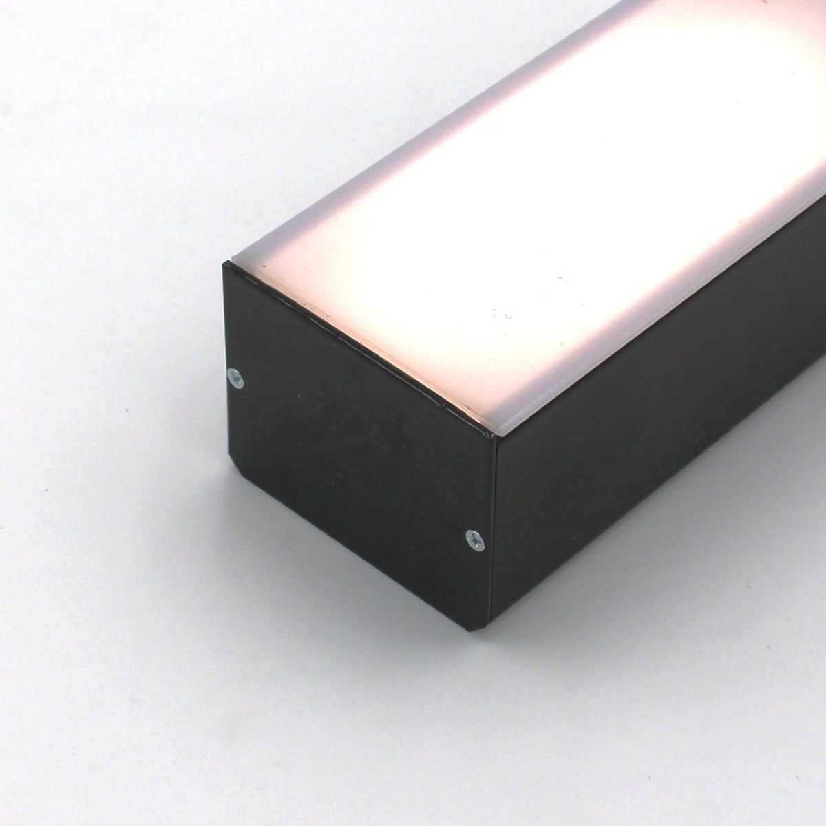 A close-up of the Black Diffuser for PL55, DPL55, RPL55, PL55-FL Profile shows its rectangular shape and reflective light pink-tinted top surface secured with screws, demonstrating effective light dispersion on a plain white background.