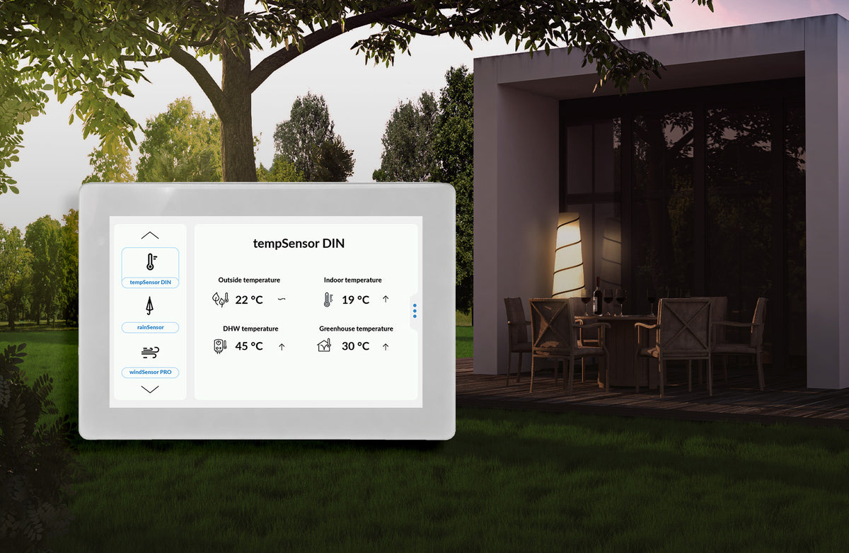 5″ Wi-Fi Touchscreen Smart Home Control Panel ~ controlPanelM by Blebox displaying temperature readings for outside, indoor, DHW, and greenhouse environments, set against a patio background.