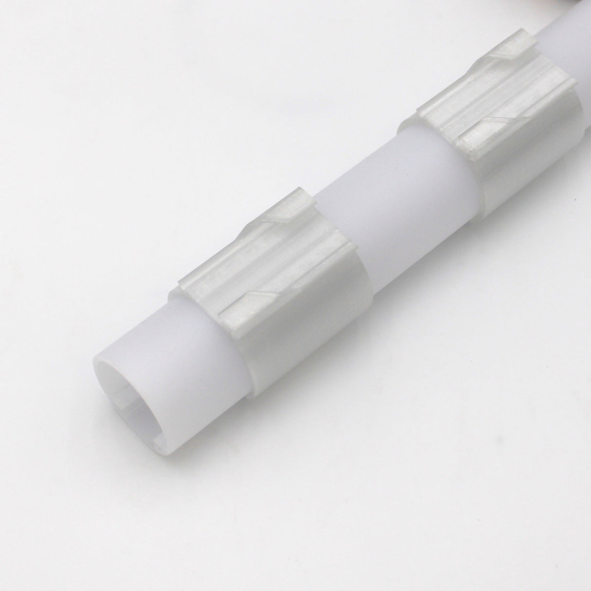 The Drop Ceiling T-Bar Clip for 1.5" Round Profiles is a white cylindrical plastic rod with two ridged silver metallic bands, shown on a plain white background.