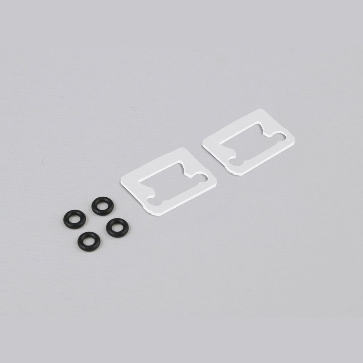 Two white metal brackets compatible with Floor8 Profile are placed next to five black rubber O-rings from the Sealing Set for Floor8 Profile on a light gray surface.