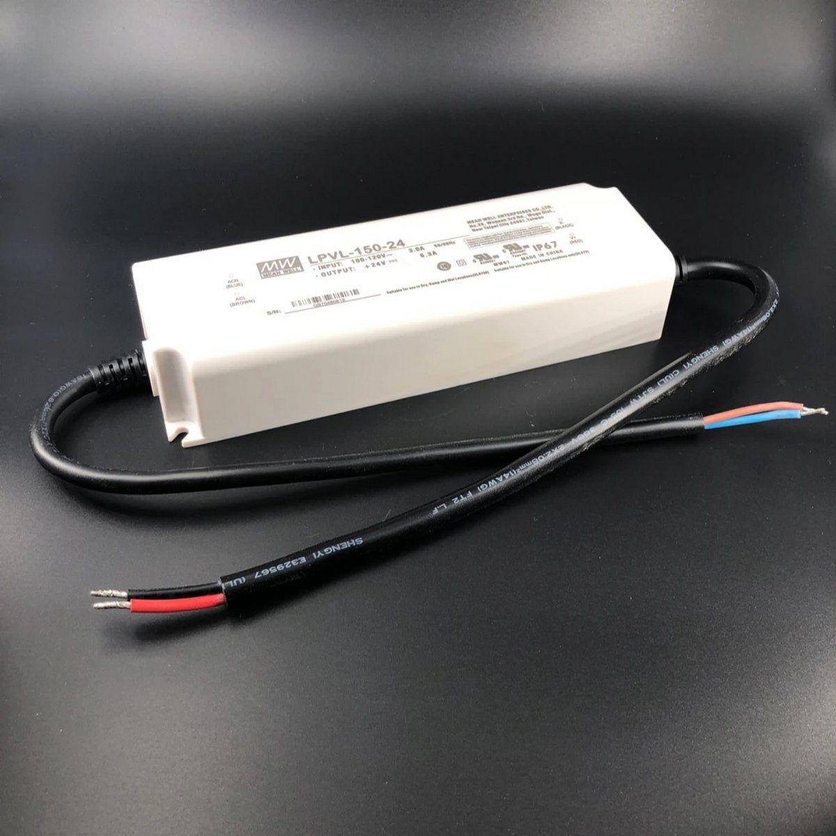 The Compact IP67 Waterproof LED Driver (24V) from the Meanwell LPV Series features a white rectangular design for outdoor use, a black cable with red, black, and blue wires, and a visible LPV-150-24 label with specifications.