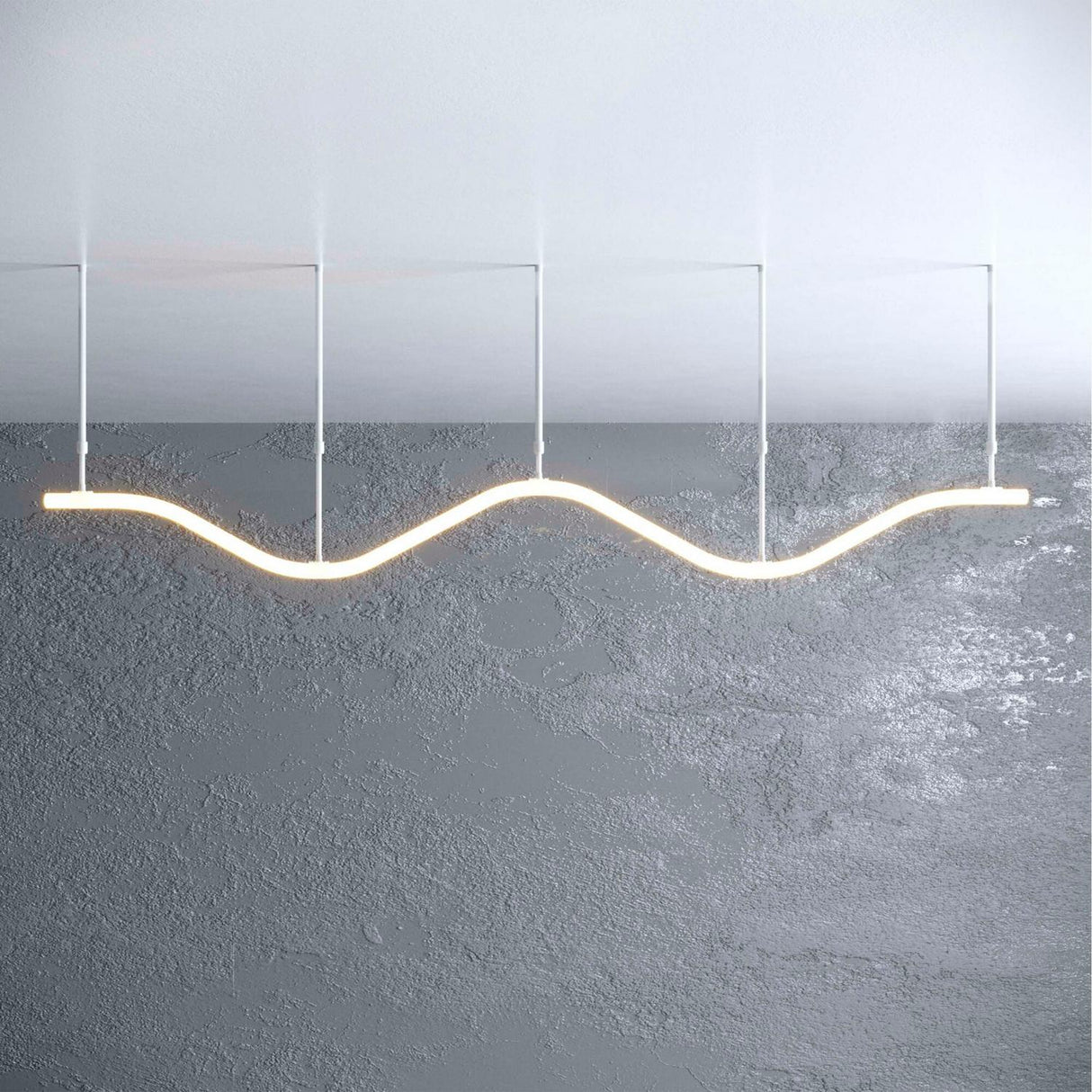 The Adjustable Suspension Arm for the Neon 360 Series allows the modern, wavy LED fixture to hang at variable lengths, illuminating a plain gray textured wall with a soft glow.