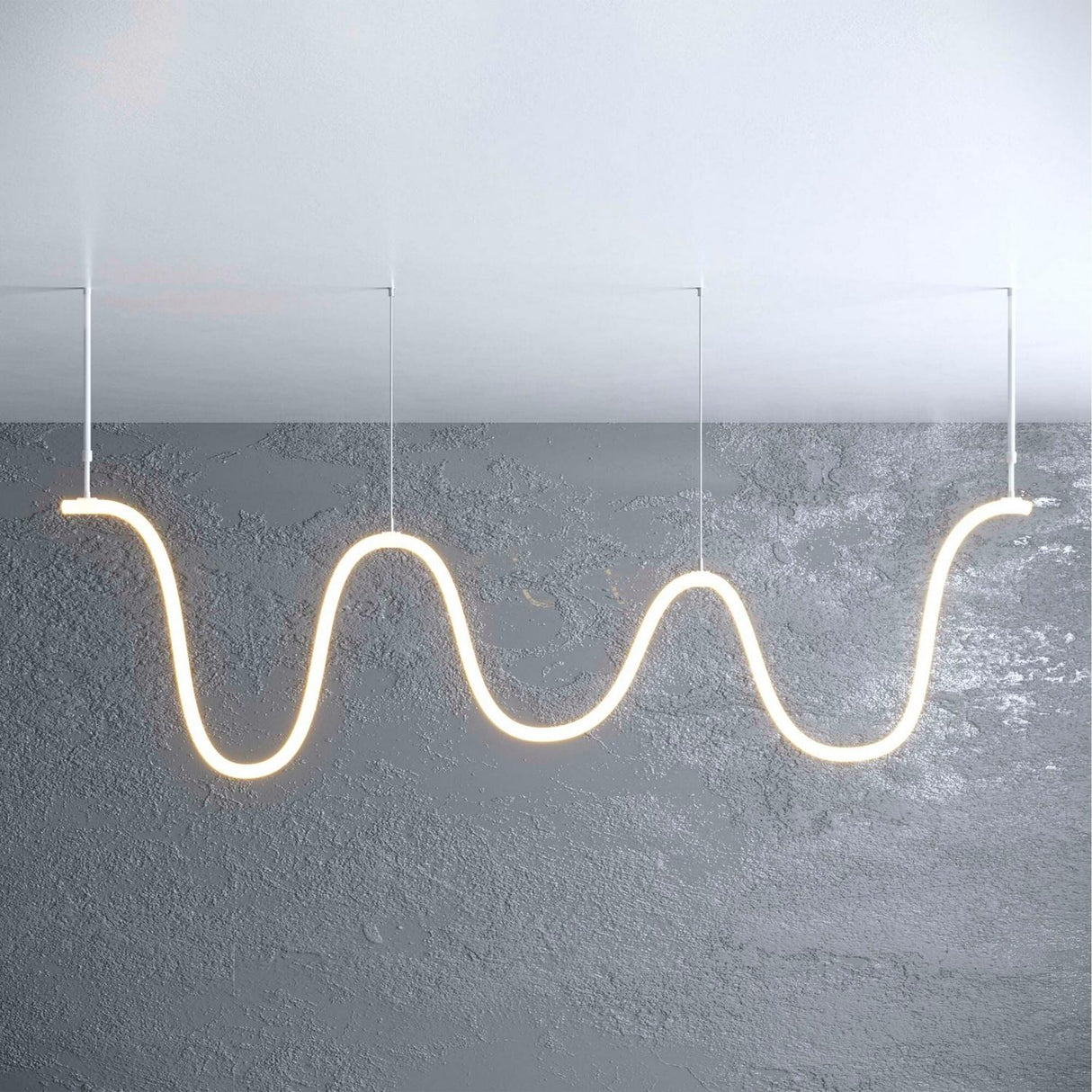 An Adjustable Suspension Arm for the Neon 360 Series supports a wavy, glowing tube pendant light, hanging elegantly from the ceiling against a textured gray wall and ceiling backdrop.