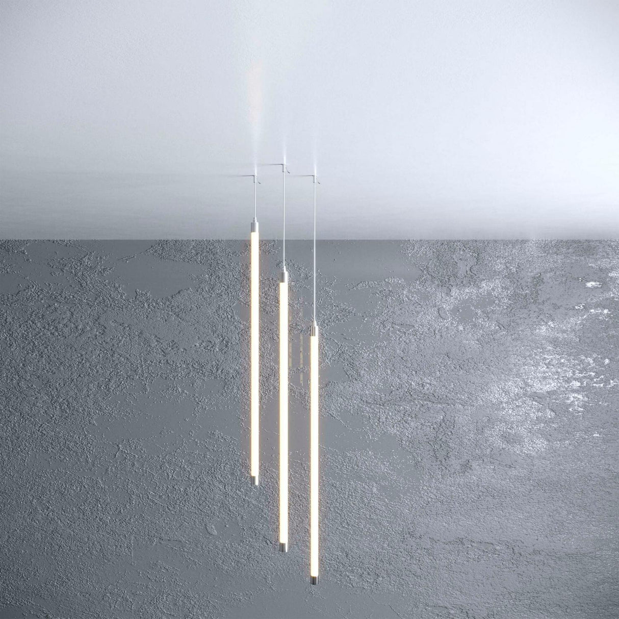 Three slim Straight Tube for Neon 360 Series pendant lights with transparent polycarbonate tubes hang from the ceiling against a textured gray wall, creating a minimalist and modern look with integrated LED lighting.