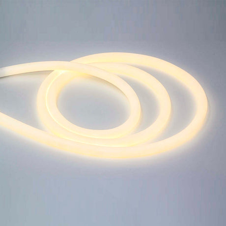 The Flexible White LED Neon Tube ~ Neon 360 Series creates loose loops on a smooth, light surface, glowing softly in warm white with full 360-degree illumination.