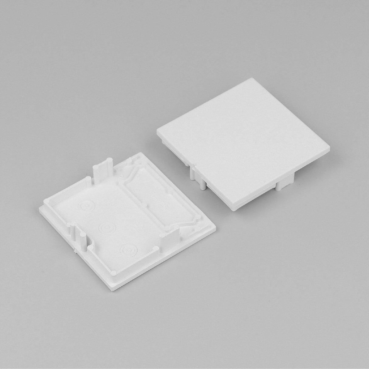 Two white, square End Caps for Phil.v2 Profile are displayed on a light gray background—one shows inner clips and grooves, while the other displays a flat front, ideal for seamless lighting fixture installation.