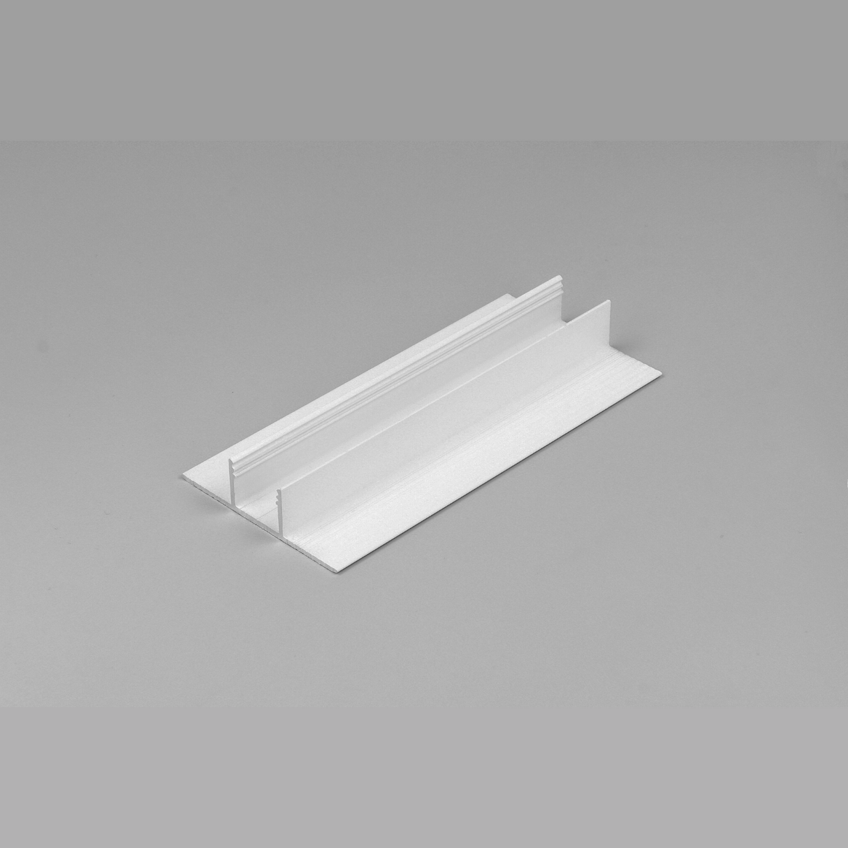 The Plaster-In Trimless Plasterboard LED Profile ~ Model Plane14-In, a white T-shaped aluminum profile with visible grooves and flanges, is shown on a gray background—perfect for seamless decorative lighting installations.