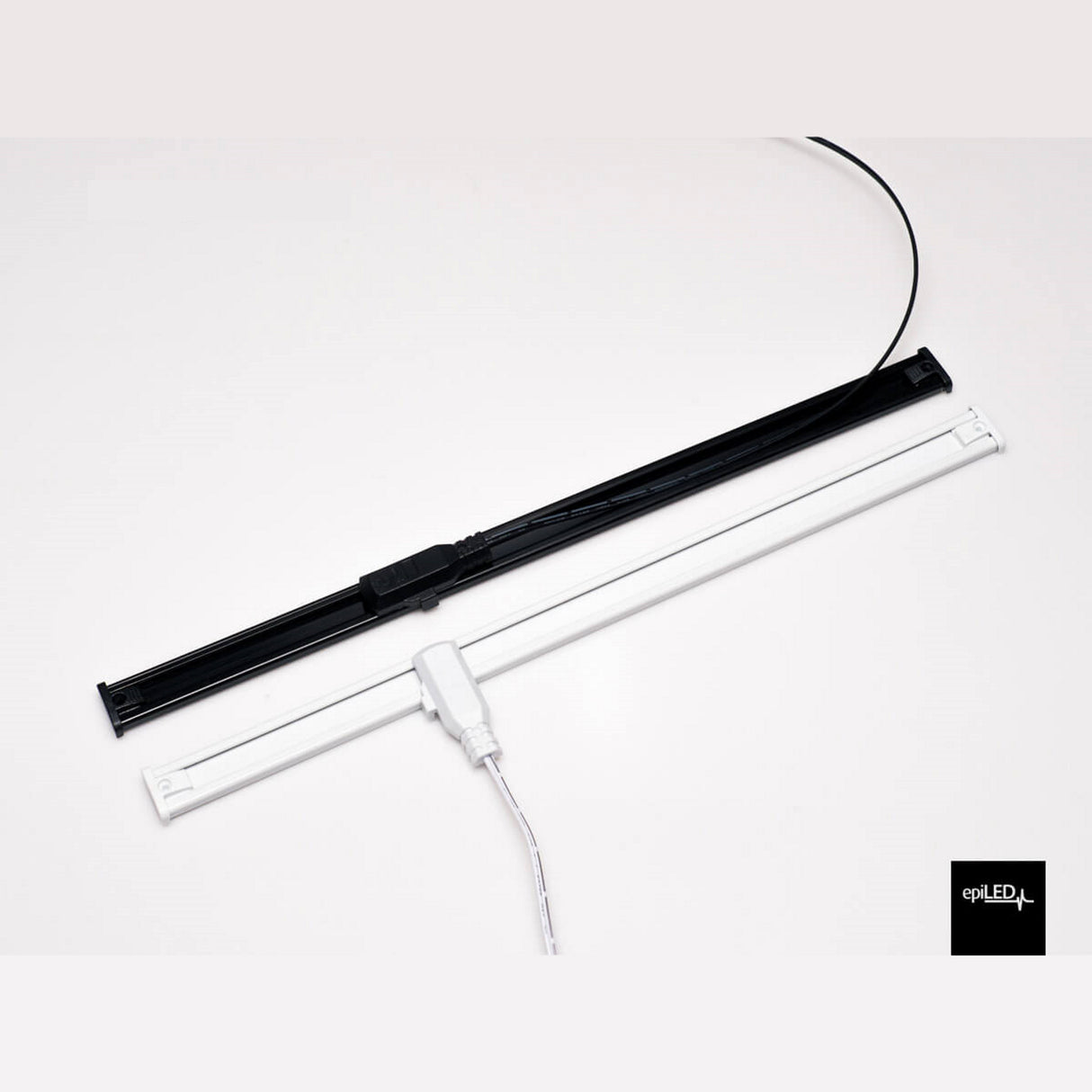 Two Power Track Twist Plug Connectors, one black and one white, are positioned parallel on a white surface, each with attached cords and a power plug. The connector on the white bar is visible; the epILED logo appears in the bottom right corner.