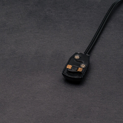A close-up of a Power Track Twist Plug Connector in black shows two visible screws and brass connectors on a dark gray textured surface.