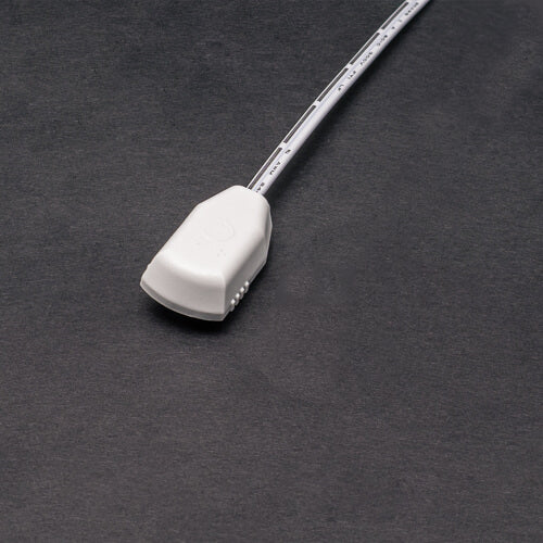 A Power Track Twist Plug Connector with a white cable and rectangular power plug is placed on a dark grey surface.