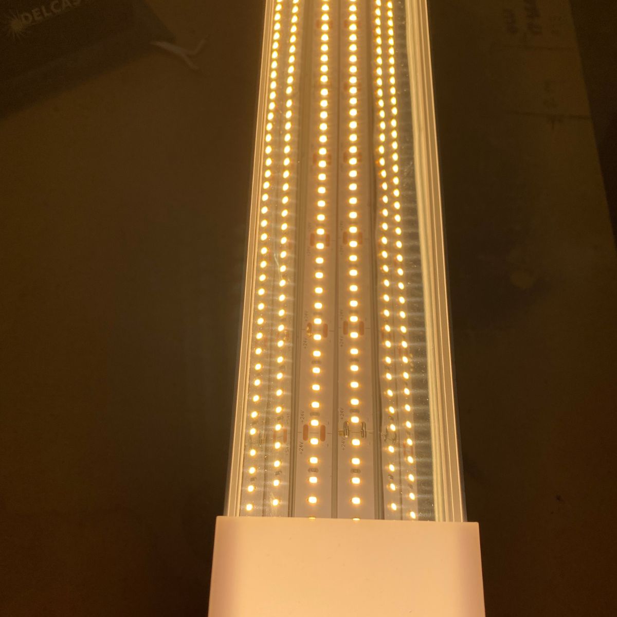 A close-up of the Light Reflector 32mm Vega95 for DPL55-FL, DPL70-FL, PL55-FL, PLW70-FL, RPL55US, RPL70US, and RPLW80FL shows parallel rows of bright white LEDs emitting a warm glow as the reflector enhances brightness against a dark background.