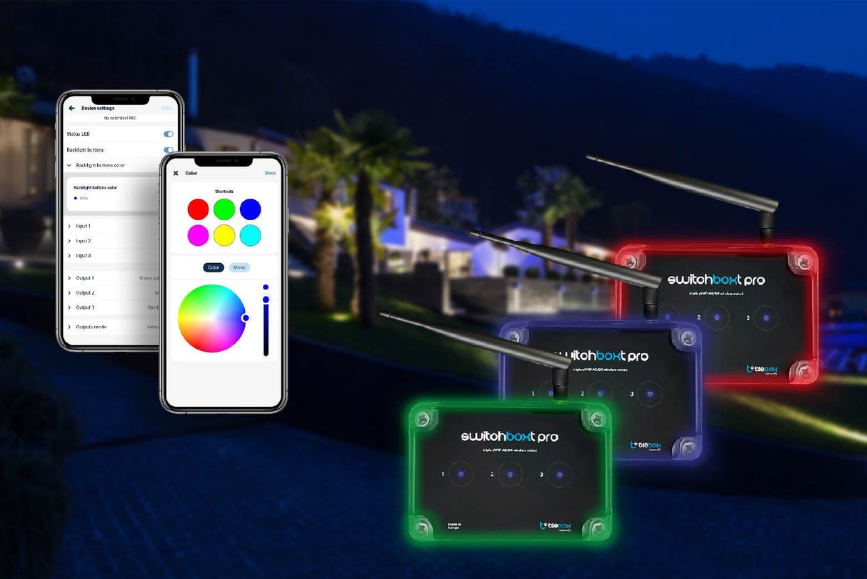 Four switchBoxT Pro wireless triple WiFi relay switch controllers in red, blue, green, and black are shown outdoors at night with two smartphones displaying customizable lighting colors and a house with palm trees in the background.