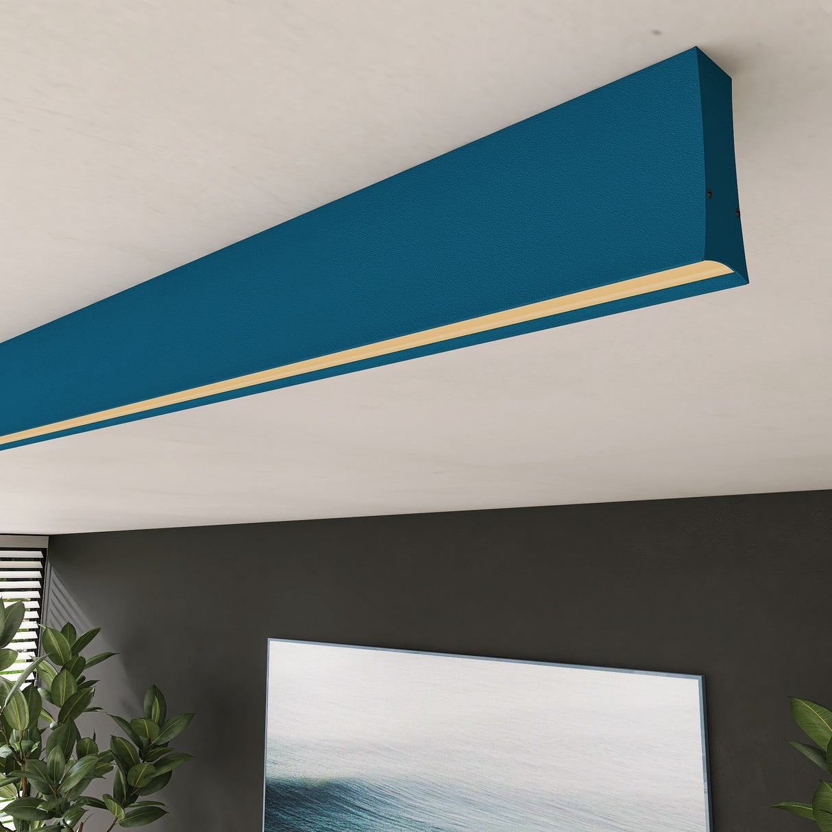 The Linear Pendant Lighting Channel ~ Model Lola, a sleek rectangular fixture with a slim illuminated strip, is mounted on a white ceiling above a modern room with dark walls, plants, and abstract artwork.