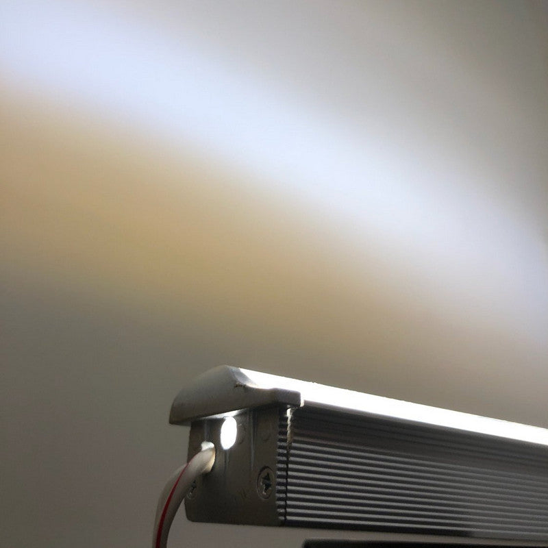 Close-up of LED Strip Vaulted Ceiling Light Channel ~ Model Alu-Asymmetric with metal casing, casting a bright white beam onto a wall; visible wiring appears on the left side of the fixture.