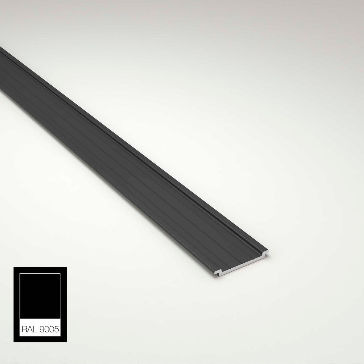 A long, narrow, black metal Complementary Profile for Antonio, Lola and Ricardo Profiles lies diagonally on a white surface. A black color swatch labeled RAL 9005 appears in the bottom left corner.