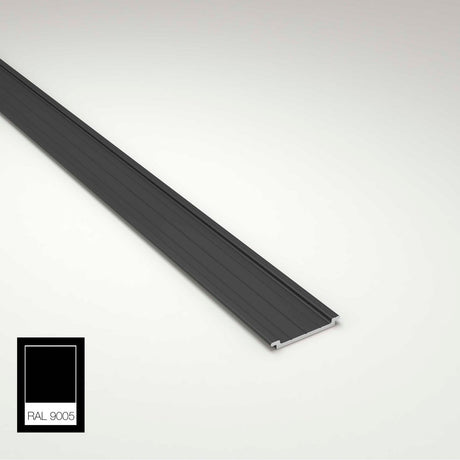 A long, narrow, black metal Complementary Profile for Antonio, Lola and Ricardo Profiles lies diagonally on a white surface. A black color swatch labeled RAL 9005 appears in the bottom left corner.