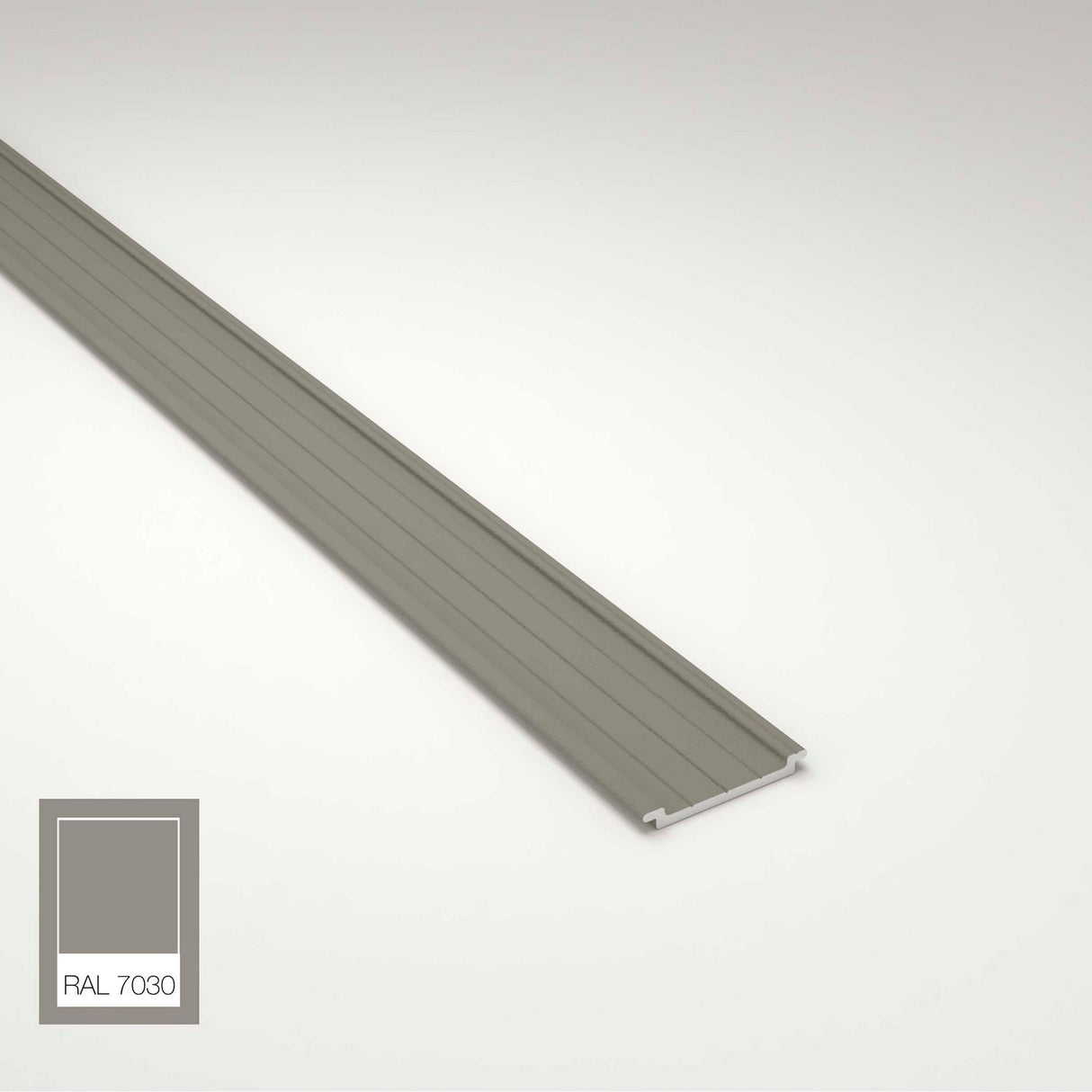 A long, narrow, gray metal strip—Complementary Profile for Antonio, Lola and Ricardo Profiles—is shown on a light surface. In the bottom left, a color swatch labeled RAL 7030 displays the matching shade.