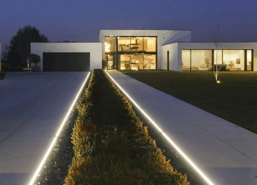 Linear LED driveway edge lighting outside a modern residence