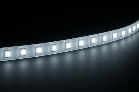 Cool white LED strip light on a dark background shining onto a reflective surface.