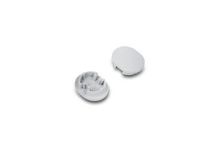 Two small, oval, white plastic D End Caps for the Arc12 Duo Profile are displayed on a white background. One end cap is inverted to reveal its inner ridged structure, while the other shows a smooth exterior. These D End Caps are specifically designed to provide a neat and finished look to the ends of an Arc12 Duo Profile lighting fixture.