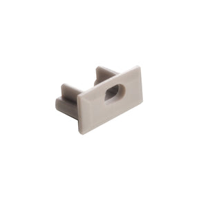The End Cap for Milano Slim Profile is a compact, light gray plastic accessory with a central slot and two parallel prongs at the back, designed to fit Milano Slim Profile lighting fixtures.
