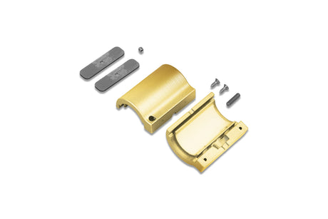 A brass-colored metal through holder for the Arc12 Duo Profile is disassembled into two halves, accompanied by two rectangular gray pieces, one small round component, two screws, and a pin—all parts neatly arranged on a white background.