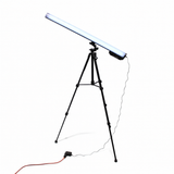 A Portable Long Range Casambi RGBW Tube Light is mounted diagonally on a black tripod stand, plugged in with a power cable and orange extension cord on the floor, creating an ideal wireless stage lighting setup against a white background.