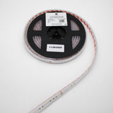 A roll of Low-Power RGBW IP67 Waterproof LED Strip (24V) ~ Iris Series is shown on a black plastic spool with a white label dated 11/28/2025, with the LED strip extending from the reel against a white background.