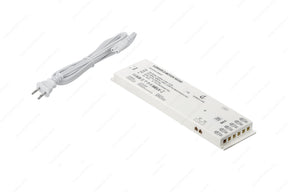 The Dimmable Plug-In LED Driver (24V) from the X-Driver D-Motion Series features a white unit with printed specs and a two-prong plug, ideal for powering D-Motion luminaires or serving as a smart LED driver in modern lighting setups.