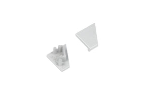 Two small, light gray, triangular plastic End Caps for the Corner10.v2 Profile—one oriented upward to reveal a smooth surface, the other inverted to display pegs and notches on the underside—sit against a white background. These components are designed specifically for use with the Corner10.v2 Profile lighting fixture, providing a clean and secure finish.