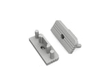 Two gray, rectangular plastic End Caps for the Surface10 Profile—designed as ideal accessories for LED channel installations—feature ridged tops and cylindrical pegs, positioned at different angles on a white background.