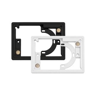 Two rectangular plastic framePanelM wall mount frames for controlPanelM screens by BleBox, one black and one white, are shown overlapping. Each frame features circular and rectangular cutouts, screw holes, and small metal contact points on their surfaces.