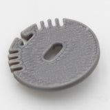 The End Cap for Alu Round Profile is a round, flat, gray plastic cap with a central oval cable hole and four small notches along one edge, designed for Alu Round LED profiles and shown on a white background.