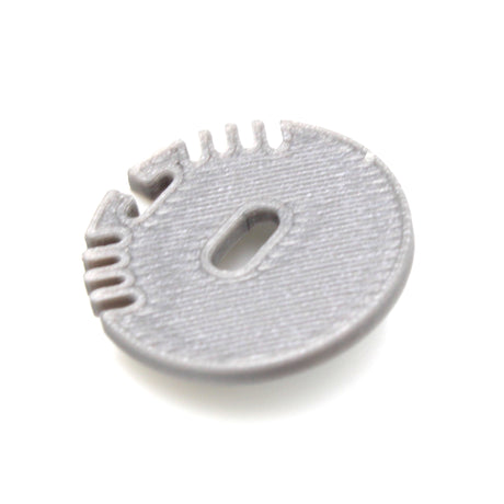 A gray, round plastic End Cap for Alu Round Profile with ridges, a central oval cable hole, and several small edge notches, shown on a white background.
