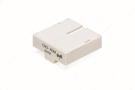 A compact, rectangular white module labeled "CM2-XDM D-Motion" with a wireless icon. The Remote Controller Module & Wireless IP/PIR Sensor is ideal for LED luminaires control and features a minimalistic, smooth-edged design.