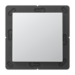 A square, silver Casambi 1-Button Wireless Wall Switch (Model Jung BLE A 590) is mounted on a black plastic frame with visible markings and slots around the edges.