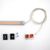 The White Universal Surface-mount LED Lighting Fixture (Begton12 Series) features a dotless LED strip with clear wire, two black brackets, screws, and orange connectors—perfect for modern under-cabinet or surface-mounted lighting.