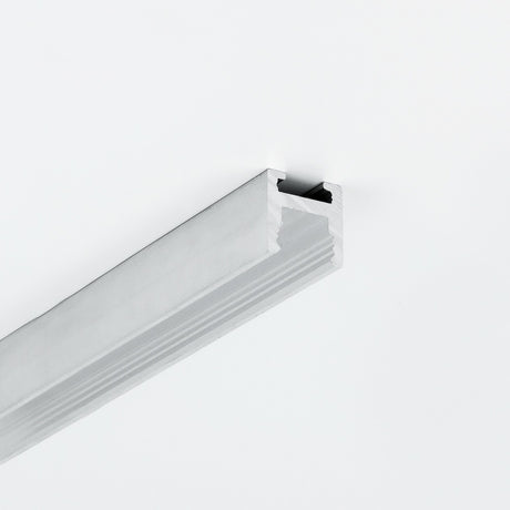A length of 0.51″ Suspended/Surface Mount Bendable LED Channel ~ Model Bend8 with a silver-toned aluminum grooved profile mounted on a white surface.