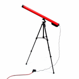 The Portable Long Range Casambi RGBW Tube Light, shown in red and mounted on a black tripod with cord and foot pedal, is ideal for stage lighting and offers wireless app control, set against a white background.