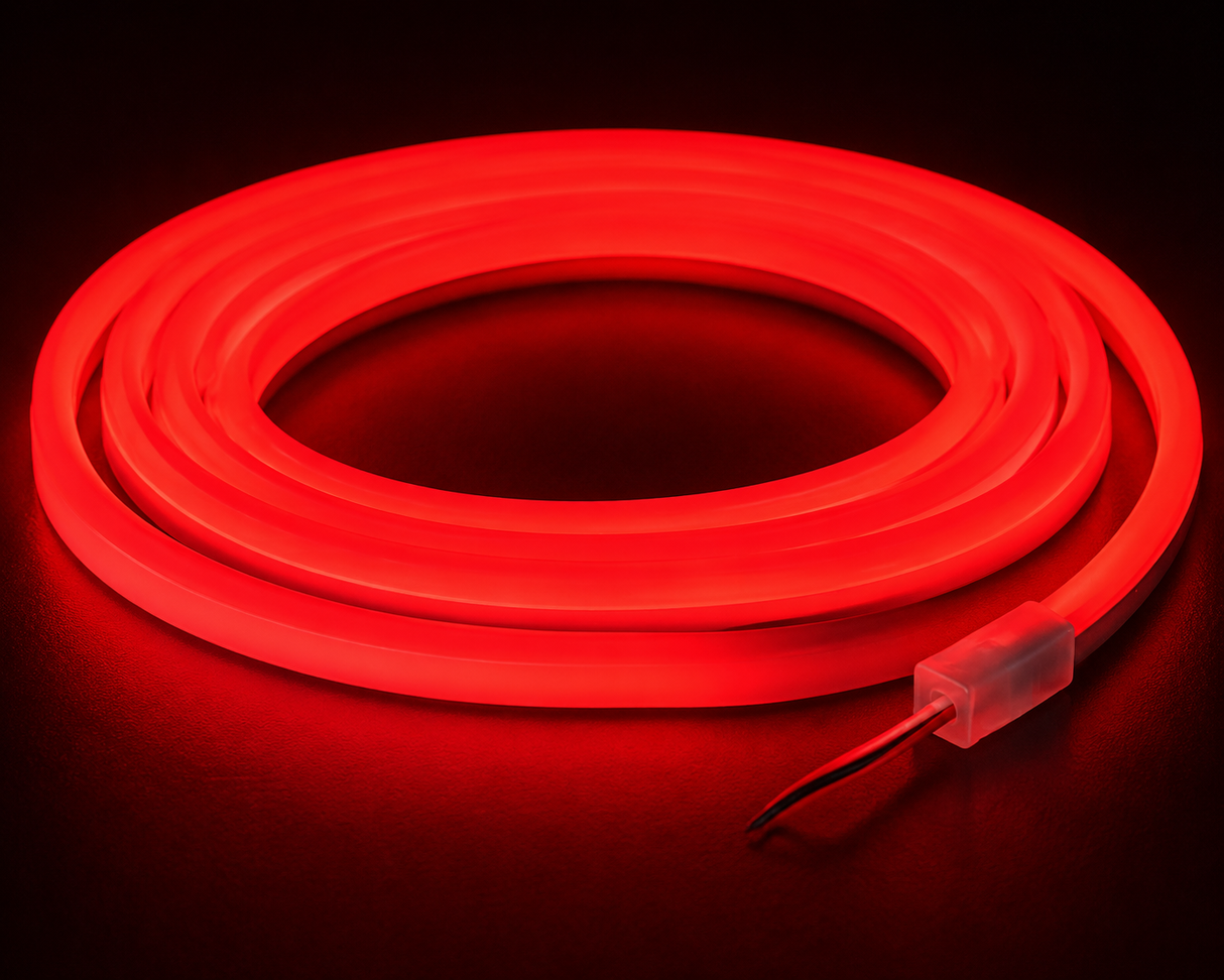 The Color IP44/IP66 Neon Flexible LED Light Line (24V) ~ Flex Ultra Slim Series emits a vibrant red glow while coiled, standing out against a dark backdrop, with two exposed wires visible at one end.