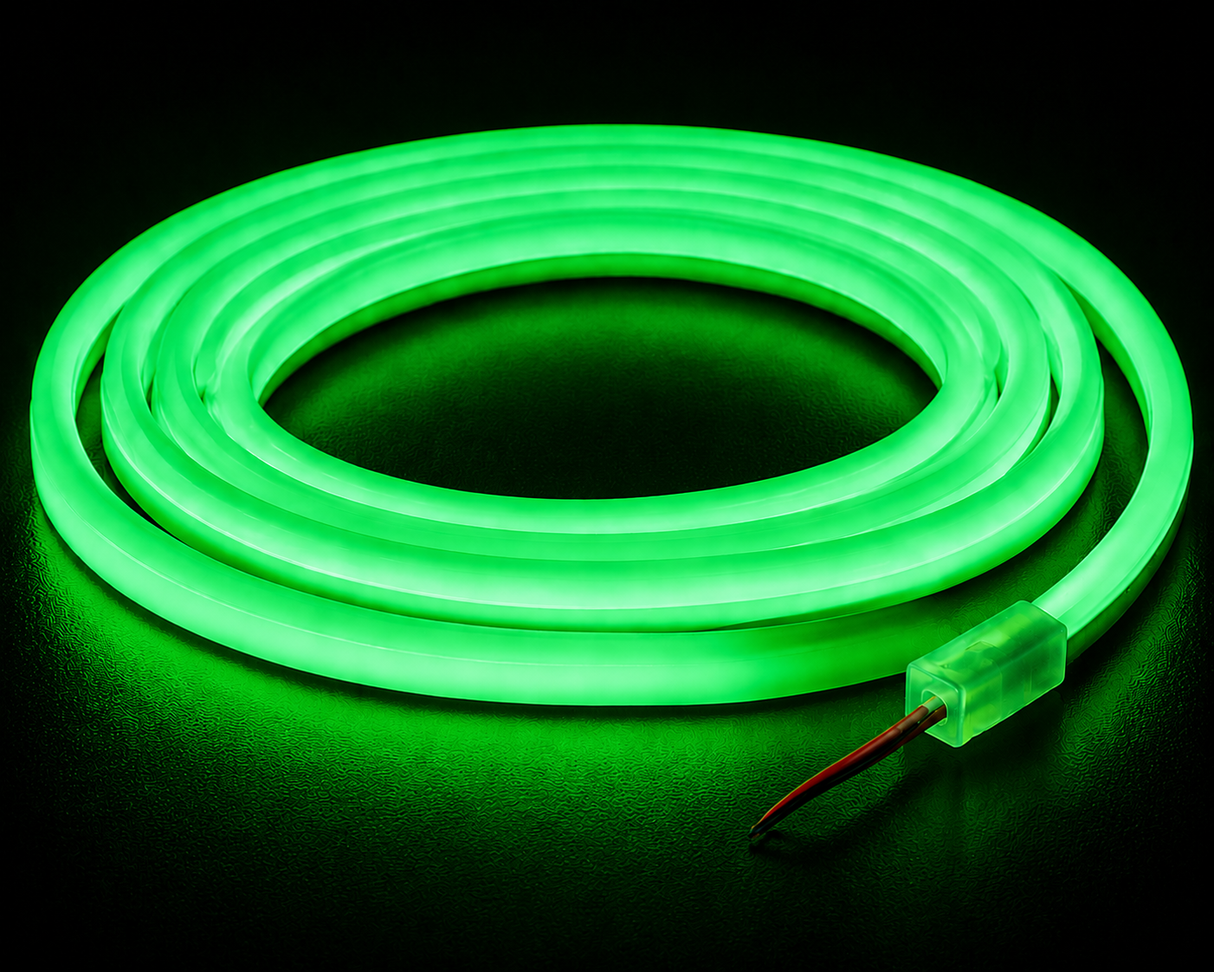 A Color IP44/IP66 Neon Flexible LED Light Line (24V) ~ Flex Ultra Slim Series, glowing green, is coiled in a circle on a dark surface, with exposed red and black wires visible at one end.