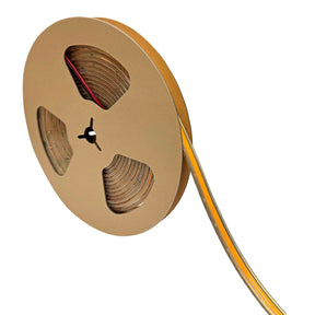 A large brown cardboard reel with cut-outs holds a partially unwound strip of Elite Gold Series Waterproof COB IP67 High CRI LED Strip (24V) flexible lighting, extending out from the reel.
