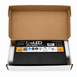 An open cardboard box with a black 5-in-1 Dimmable J-Box LED Driver (24V) from the EnoLED JPro Series resting between white foam inserts, displaying input and output details on its label; this versatile unit serves as a 5-in-1 dimmable universal LED driver, ensuring broad compatibility with diverse lighting applications.