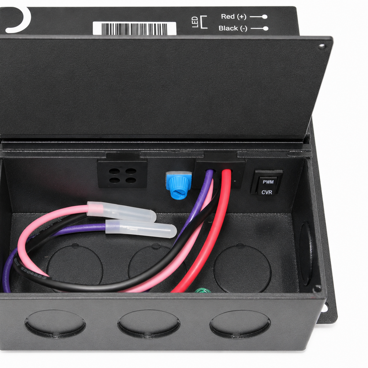 Open black metal electrical box with three wires (red, black, and purple) connected inside, a blue wire connector, and a switch labeled PWM CVR. Three circular knockouts are visible at the bottom. This setup is compatible with the 5-in-1 Dimmable J-Box LED Driver (24V), part of the Enoled JPro Series, for controlling dimmable lighting applications.