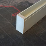 A close-up of a rectangular aluminum Hannover Profile featuring the Plastic End Cap, resting on a dark surface with red and gray patterns.