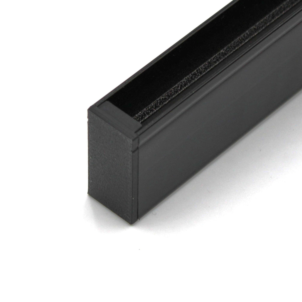 Close-up of a black Hannover Profile with a textured top edge, featuring a precisely fitted Plastic End Cap for Hannover Profile—possibly part of hardware or a structural component.
