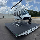 A white helicopter parked on an asphalt lot atop a transport dolly, with Up-and-Down Stair Lighting LED Channel ~ Model Niza Duo profiles visible nearby.
