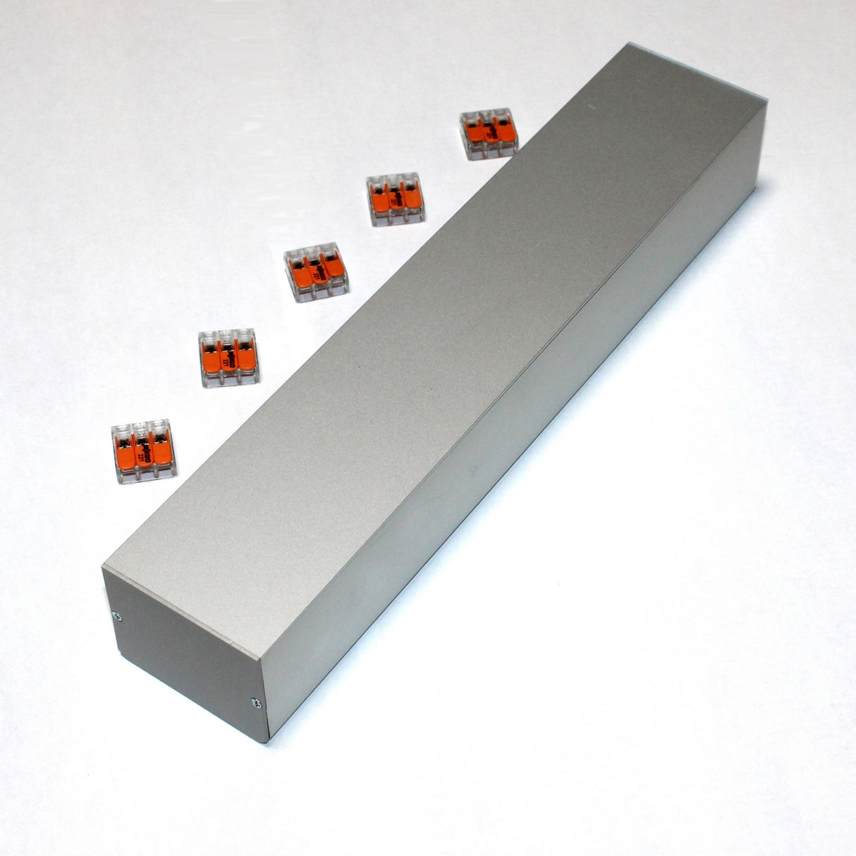 A Custom PL55 J-Box is set on a white surface, surrounded by six small orange and transparent wire connectors for secure electrical connections.