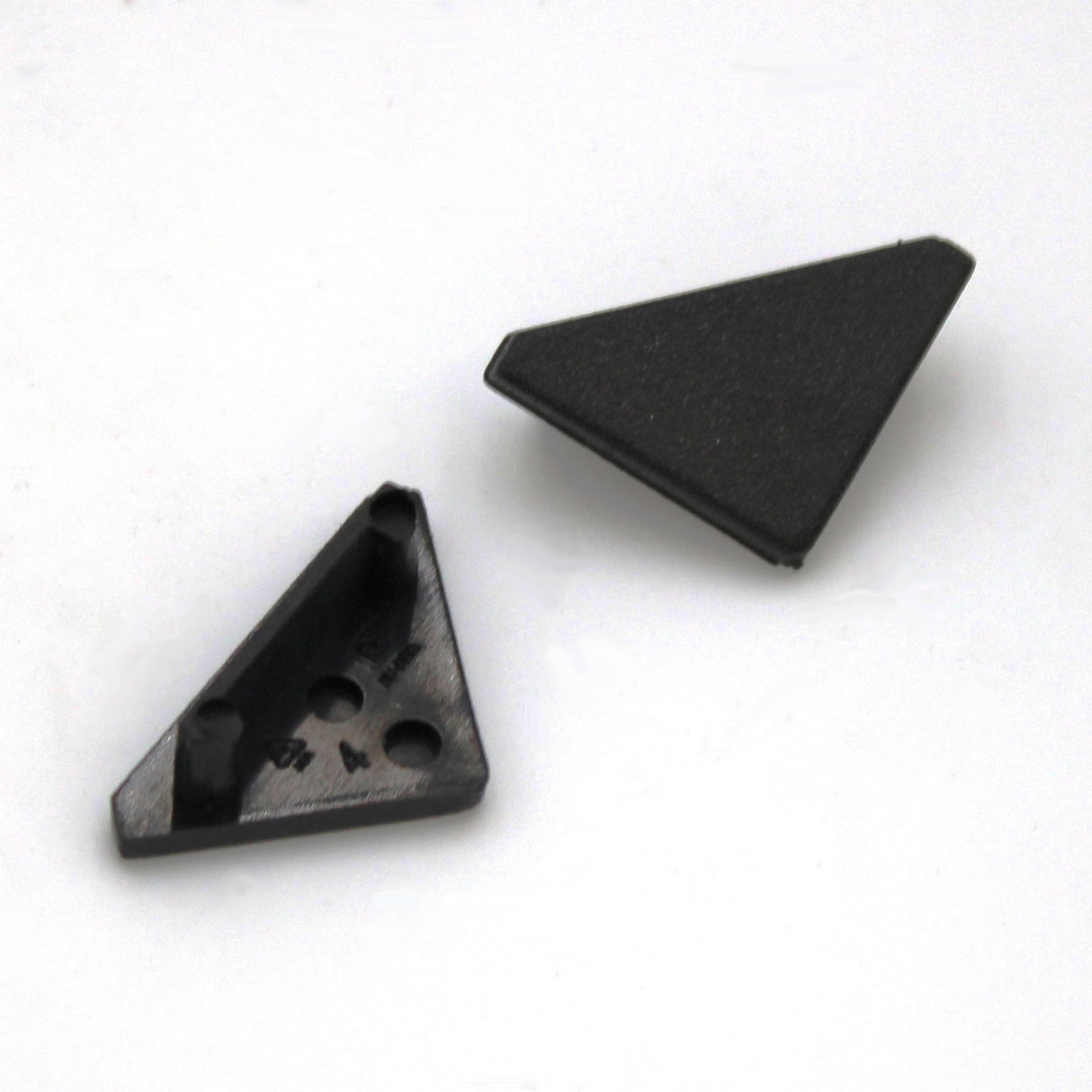Two small black plastic End Caps for Cabi12 Profile are shown on a white background, one facing up and the other down, exposing three cylindrical pegs—ideal as LED channel accessories for corner mount installations.